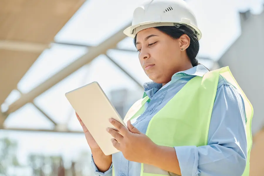 Ingeniera con casco consultando una tableta en obra