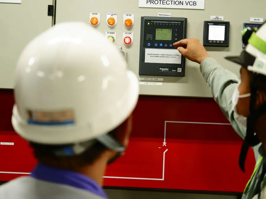 Técnicos operando un cuadro eléctrico industrial